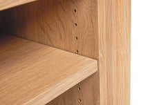 Load image into Gallery viewer, detailed view of the cascade desk. White oak finish. This image is a detailed view of the brass accents used for modular storage mounting holes inside the open storage area of this custom designed office desk. 