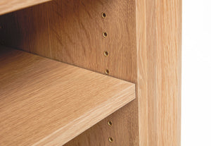 detailed view of the cascade desk. White oak finish. This image is a detailed view of the brass accents used for modular storage mounting holes inside the open storage area of this custom designed office desk. 